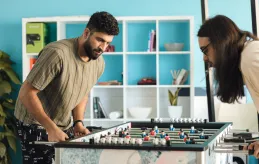 Two people playing table soccer.