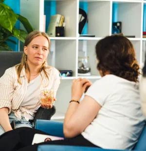 Two women sitting on couches having a conversation.