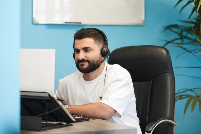 A man wearing headphones working on his laptop.